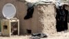 A TV satellite dish sits next next to a makeshift home in Baghdad's Al-Dora slum. (file photo)