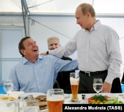 Президент Росії Володимир Путін і колишній канцлер Німеччини, а нині голова ради директорів компанії «Роснефть» Ґергард Шредер на зустрічі з учасниками реалізації проєкту «Північний потік» на газокомпресорній станції «Портова» в місті Виборгу, Росія, 2011 рік