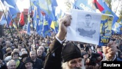 Активист держит плакат, c изображением президента Виктора Януковича, на митинге в честь 68-й годовщины Украинской повстанческой армии. Иллюстративное фото.