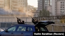 Ukrainian police officers shoot at a drone during a Russian attack in Kyiv on October 17.