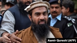 Pakistani security personnel escort Zaki-ur-Rehman Lakhvi as he leaves court after a hearing in Islamabad on January 1.