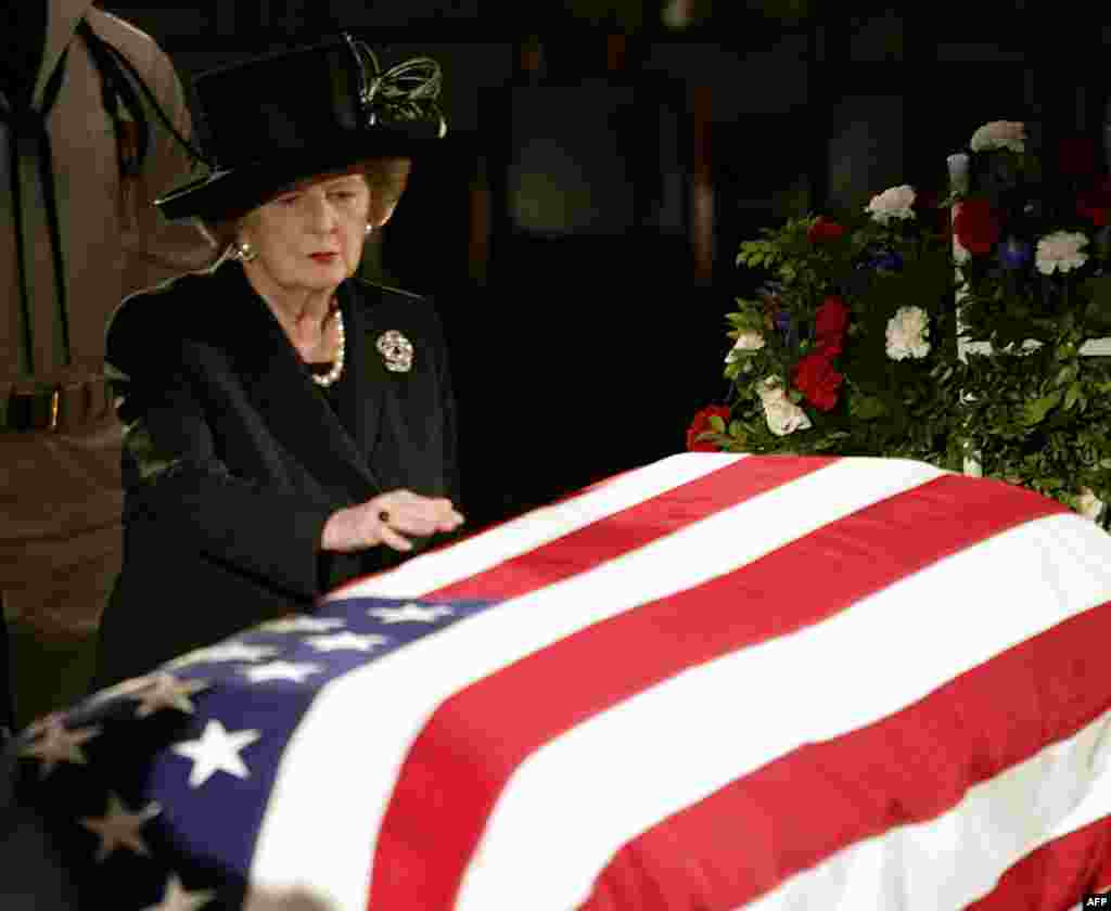 Margaret Thatcher reaches out to touch the flag-draped coffin of former U.S. President Ronald Reagan as he lies in state at the U.S. Capitol in June 2004.