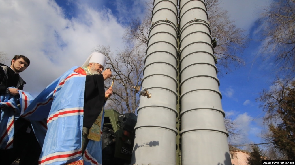 Окупований Крим. Митрополит Української православної церкви (Московського патріархату) Платон благословляє російську зенітну ракетну систему великої і середньої дальності С-400 «Тріумф», розгорнуту в Феодосії, 14 січня 2017 року