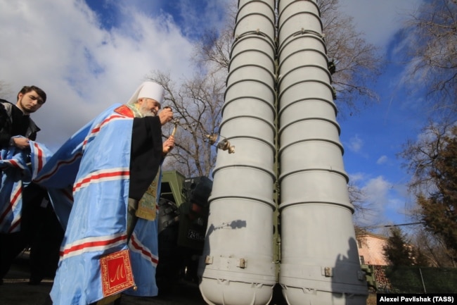 Окупований Крим. Митрополит УПЦ (Московського патріархату) Платон благословляє російську зенітну ракетну систему великої і середньої дальності С-400 «Тріумф», розгорнуту в Феодосії, 14 січня 2017 року