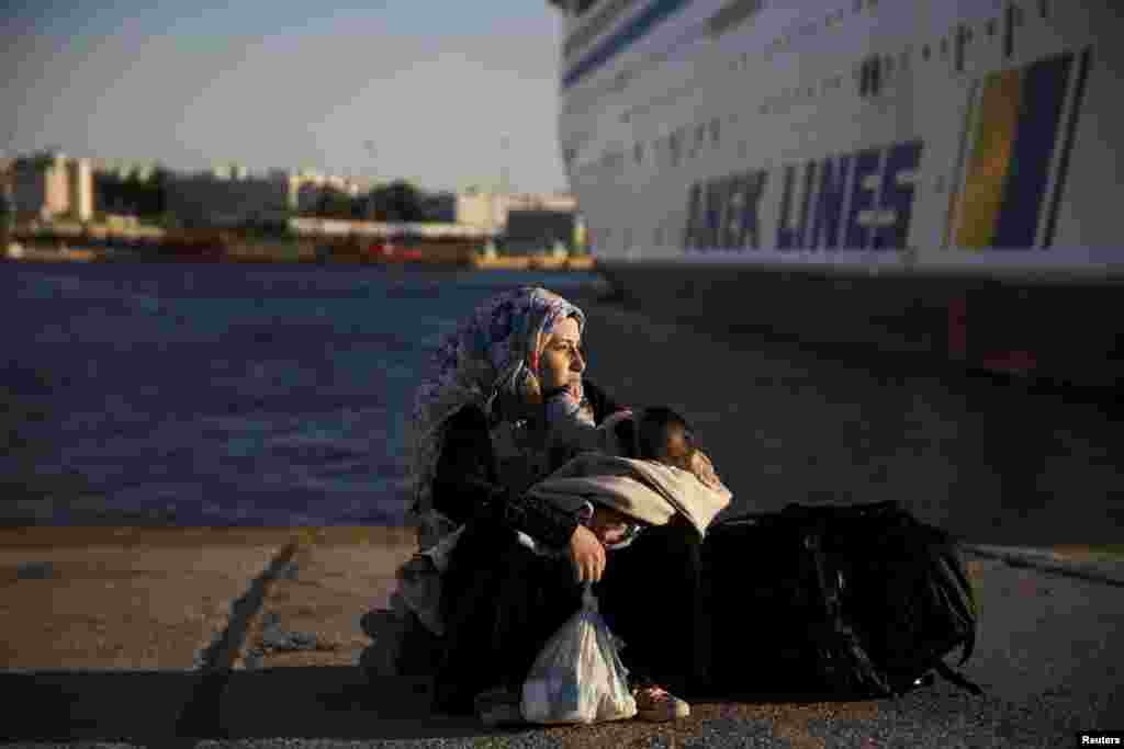 A Syrian refugee holds her baby after arriving aboard the passenger ferry Eleftherios Venizelos from the island of Lesbos at the port of Piraeus, near Athens. (Reuters/Alkis Konstantinidis)