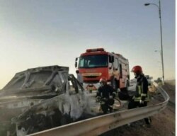 Emergency workers remove a car which exploded into flames after Iranian police reportedly opened fire on it in early June. Akram was traveling in the car (file photo).