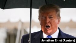 U.S. President Donald Trump speaks to reporters as he and first lady Melania Trump depart Washington for travel to a NATO summit in London on December 2.