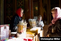 Tamara (left) sells candles to worshipers at St. Volodymyr’s Cathedral in Kyiv on October 12.