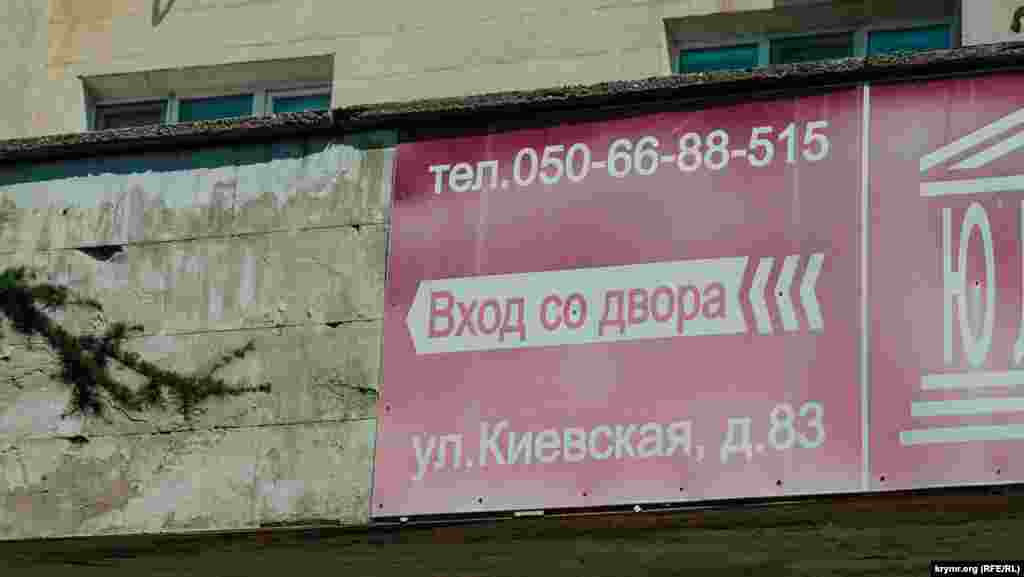 Старая вывеска адвокатской кампании с украинским мобильным телефоном