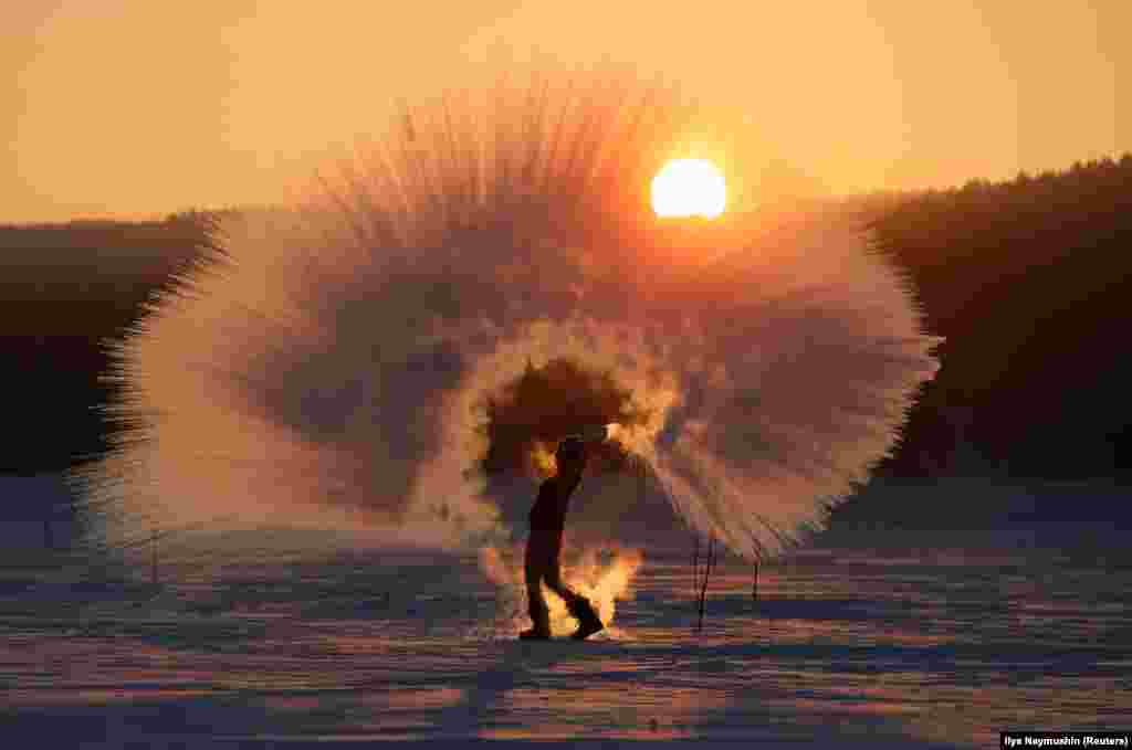 Olesya Ushakova throws hot water into the air in freezing weather near the Siberian city of Krasnoyarsk, Russia. (Reuters/Ilya Naymushin)&nbsp;