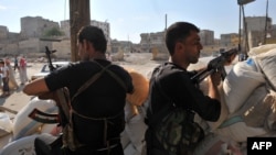 Syrian rebels man a checkpoint in Aleppo.