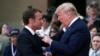 U.S. President Donald Trump (R) talks with French President Emmanuel Macron during a French-US ceremony at the Normandy American Cemetery and Memorial in Colleville-sur-Mer, Normandy, June 6, 2019