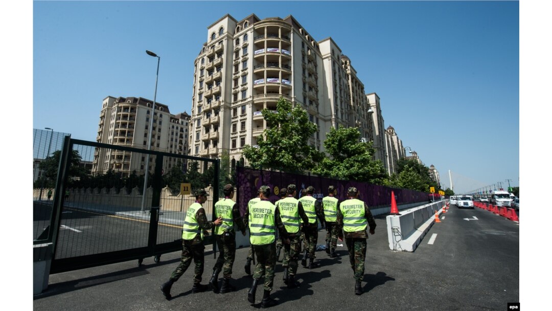 Security staff walks along a street in front of the Athletes' Village prior to the 2015 European Games in Baku.
