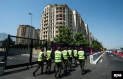 Security staff walks along a street in front of the Athletes' Village prior to the 2015 European Games in Baku.