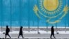 Люди на улице в Астане на фоне флага Казахстана