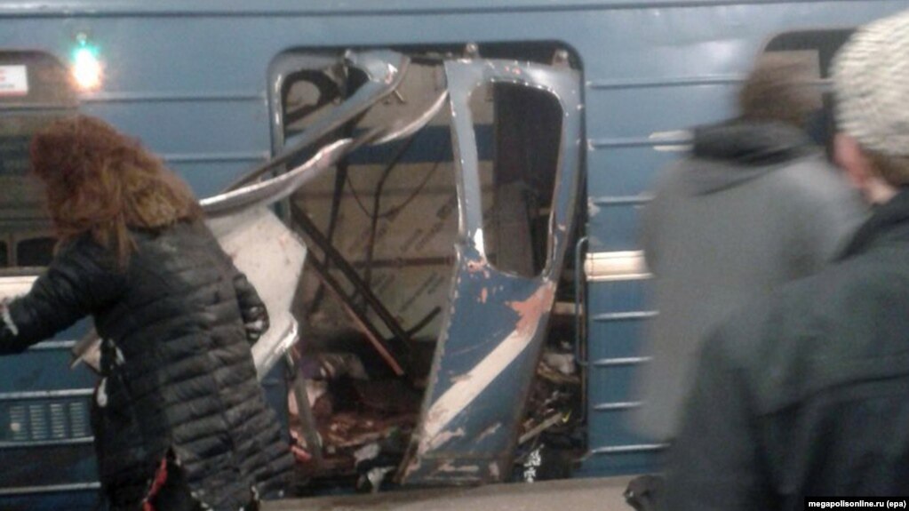 People gather in front of a damaged train door shortly after an explosion in St. Petersburg's subway on April 3.