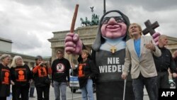 Abuse victim Heinz-Juergen Overfeld (right) and activists against sexual abuse in the Roman Catholic Church demonstrate with a giant nun puppet in front of the Brandenburg Gate in Berlin on September 22, at the start of Pope Benedict's visit.