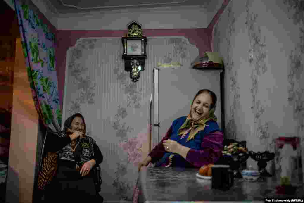 Nina (left) and Jovhar drink tea in a kitchen in the Alatava 2 district