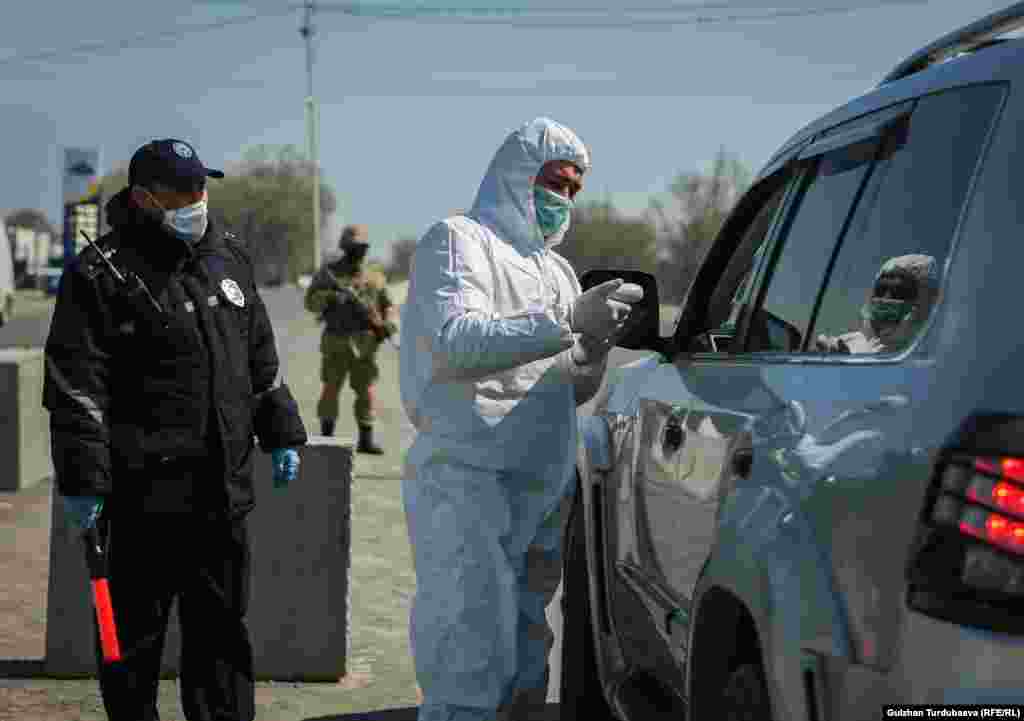 Бишкекке кире бериш жолдогу Жол коопсуздугун көзөмөлдөө бекетинин кызматкерлери айдоочулардын ар биринин дене табын текшерүүдө. 