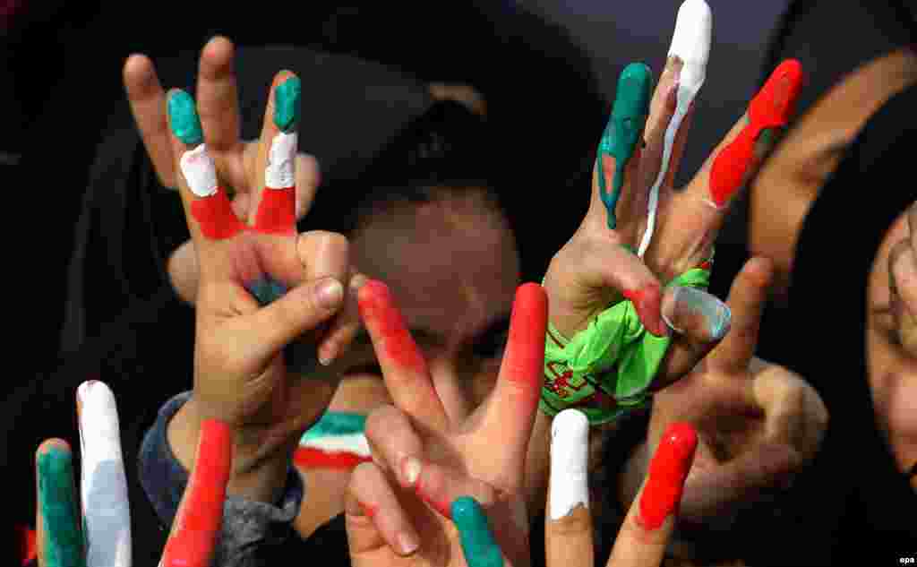 Students show their fingers painted with Iran&#39;s national flag during a ceremony marking the 35th anniversary of the 1979 Islamic Revolution, on Azadi (Freedom) Square in Tehran on February 11. (epa/Abedin Taherkenareh)