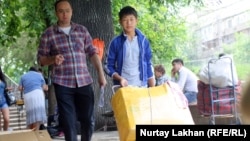 Подросток перевозит на тележке коробку с одеждой для перепродажи. Алматы, 11 июня 2013 года.