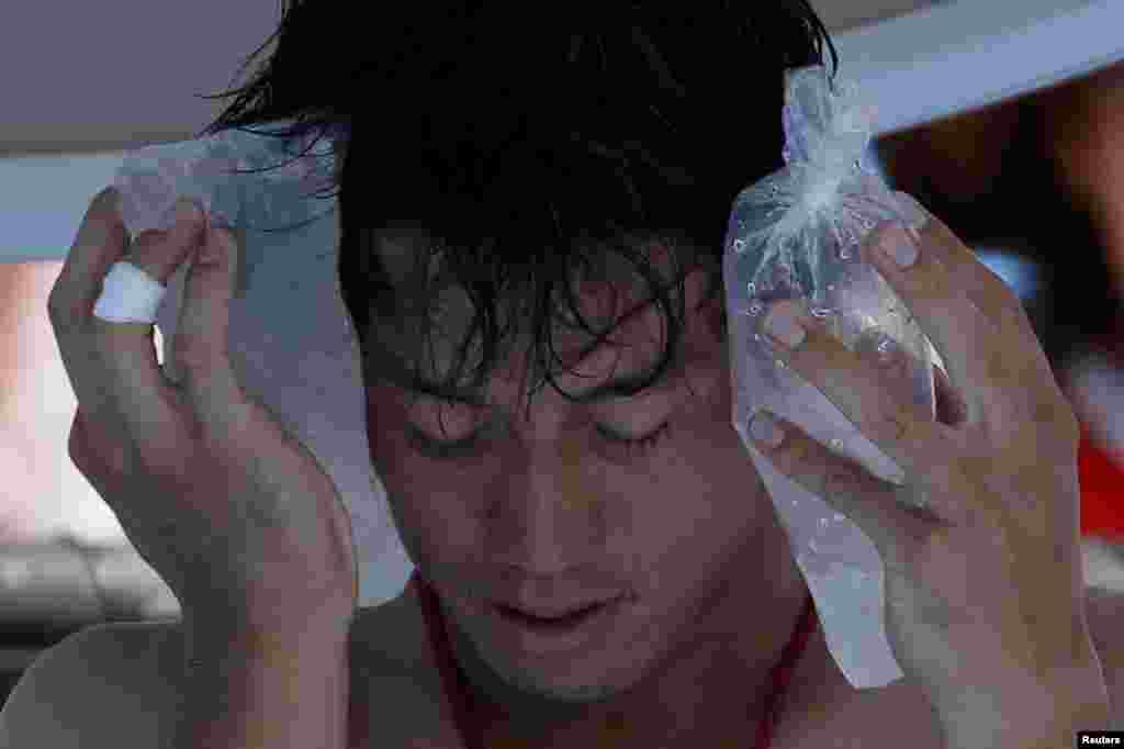 Kei Nishikori of Japan holds an ice pack to his face during his men's singles match against Dusan Lajovic of Serbia at the Australian Open tennis tournament in Melbourne on January 16.