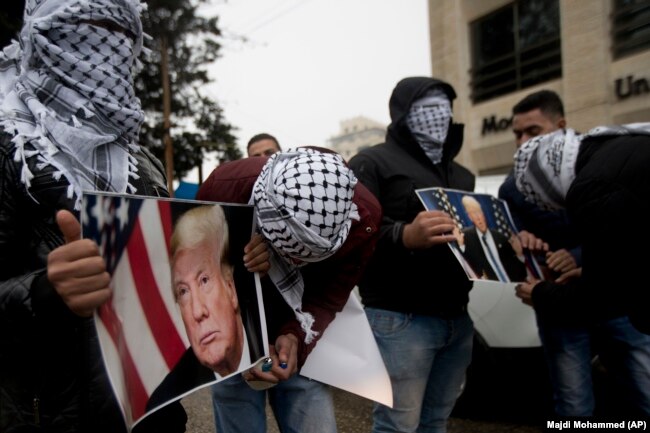 Палестинские активисты в Рамалле несут сжигать портреты Дональда Трампа. Вечер 6 декабря 2017 года