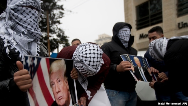 Palestinezët mbajnë në duar fotografi të presidentit Donald Trump, gjatë një proteste në qytetin Ramallah më 6 dhjetor.