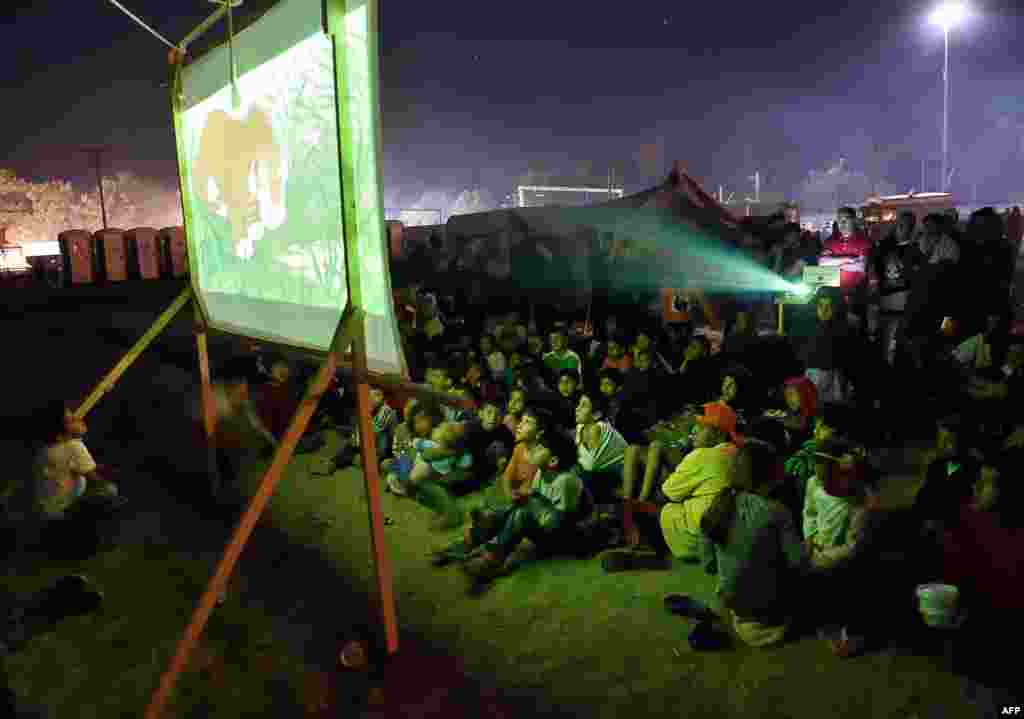 Grek-makedon serhedi, Idomeni obasynyň golaýyndaky bosgun lageri, multfilm görýän bosgun çagalary. (AFP/Daniel Mihailescu)