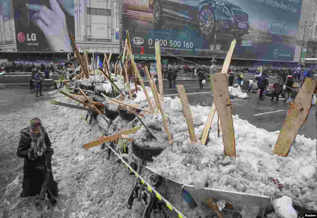 A woman walks near a barricade on Khreschatyk Street in central Kyiv, where pro-European integration protesters were barricaded in. (Reuters/Gleb Garanich)