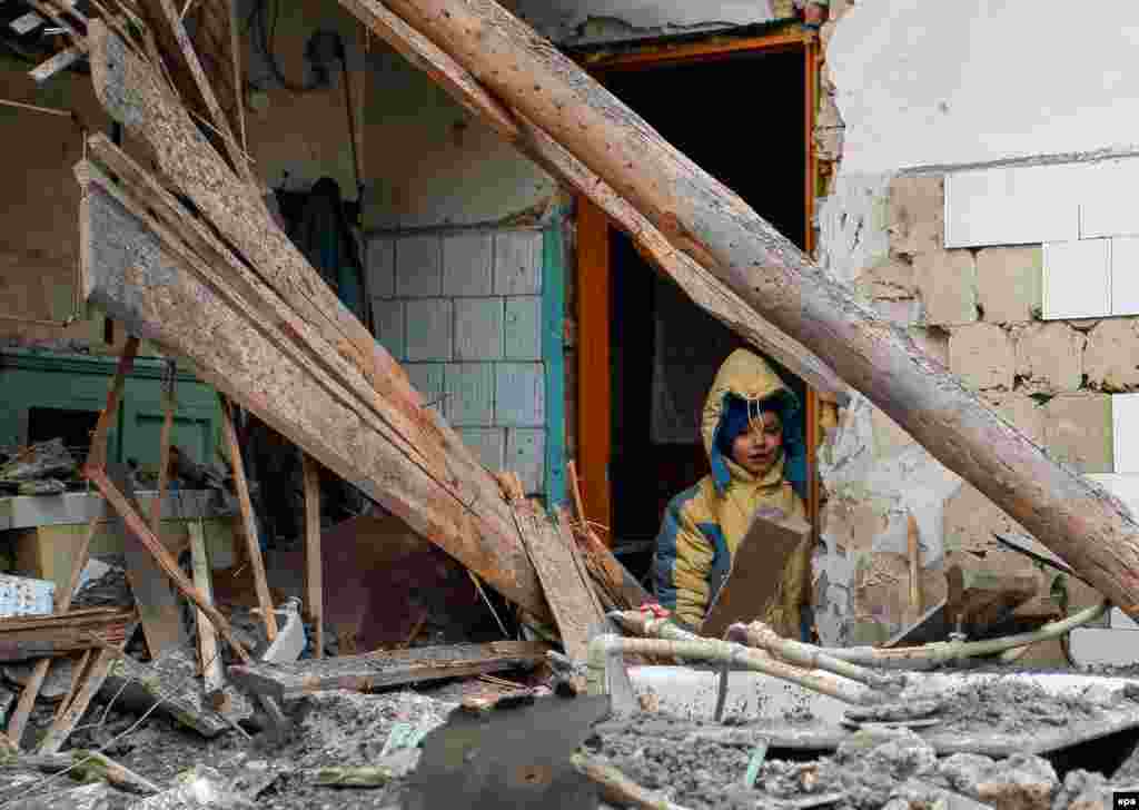 A boy stands at the doorway of his damaged house after it was hit by shelling in the separatist-controlled city of Donetsk, Ukraine. (epa/Aleksandr Yermochenko)