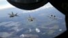 Two F-22 Raptor fighter jets and an A-10 Thunderbolt approach the refueling nozzle of a KC-135 Stratotanker as they fly near the Estonian capital of Tallinn toward the newly established NATO air base of Aemari. (Reuters/Wolfgang Rattay)