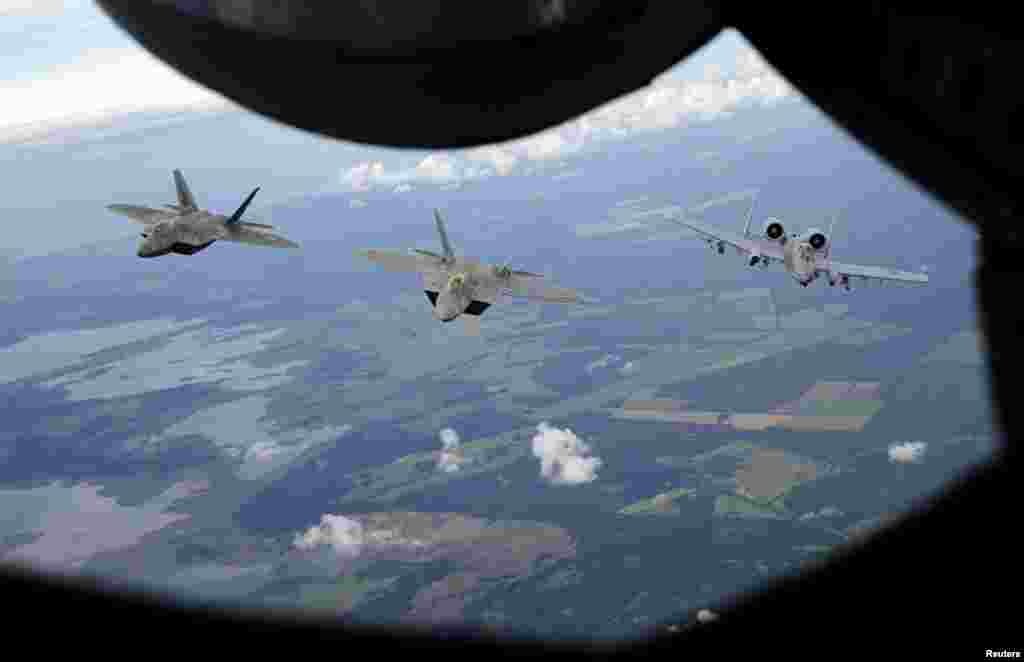 Two F-22 Raptor fighter jets and an A-10 Thunderbolt approach the refueling nozzle of a KC-135 Stratotanker as they fly near the Estonian capital of Tallinn toward the newly established NATO air base of Aemari. (Reuters/Wolfgang Rattay)