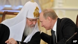 Владимир Путин (справа) беседует с патриархом Русской православной церкви Кириллом. Архивное фото