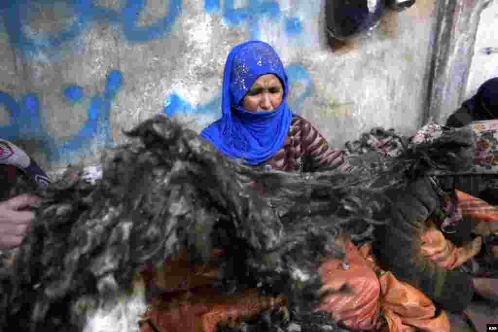 Një grua afgane duke punuar në një fabrikë leshi në Herat, pa pajisjet e nevojshme si dorëzat dhe maskat mbrojtëse.&nbsp;