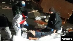 Спасатели уносят тела погибших после того, как в центре Берлина грузовик врезался в рождественскую ярмарку.