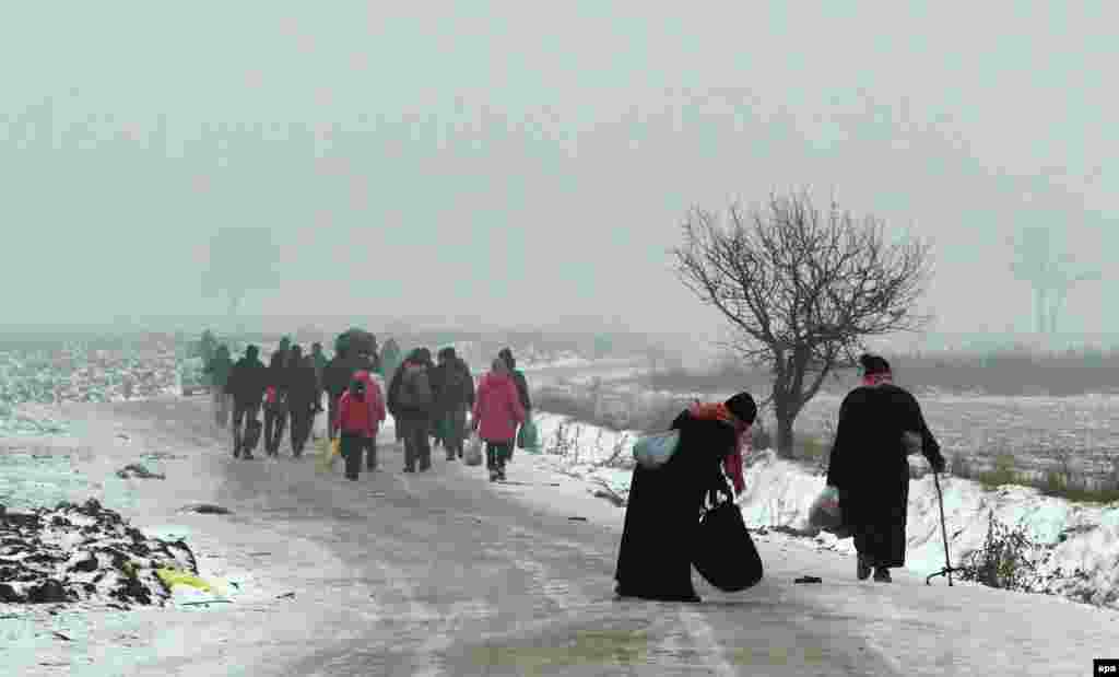 Migrants travel on foot from Macedonia to a camp for the temporary acceptance of migrants in the village of Miratovac on the border between Serbia and Macedonia, near to the southern Serbian city of Presevo. The number of migrants entering Serbia has not decreased, despite snow and low temperatures. About 1,000 migrants arrived from Macedonia by train on the morning of January 5. (epa/Djordje Savic)