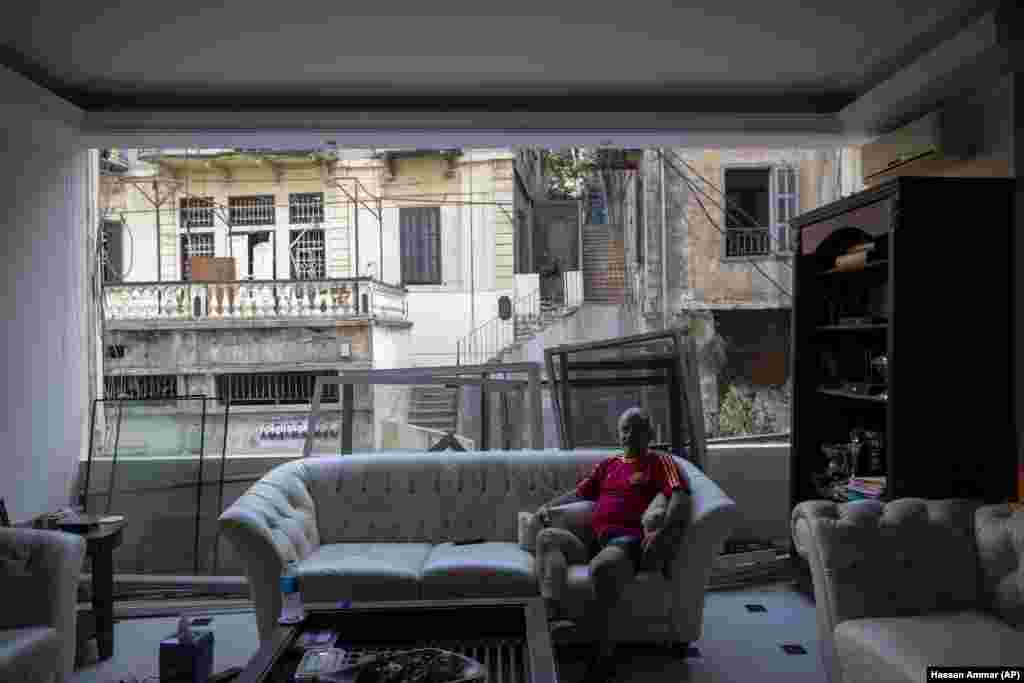 George Abdo, 58, poses for a photograph inside his destroyed apartment after Tuesday's explosion in the seaport of Beirut, Lebanon, Thursday, Aug. 6, 2020.