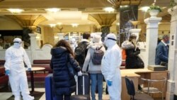 Zdravstveni radnici pregledaju putnike koji odlaze za Rusiju iz Kijeva, 27. mart 2020.