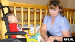 Жанетта Жазыкбаева, директор Шымкентского фонда защиты детей от СПИДа, и мальчик Жарас, зараженный ВИЧ. Шымкент, 22 мая 2010 года.