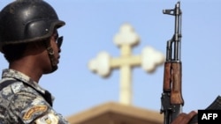 An Iraqi policeman stands guard outside a church in the Baghdad district of Dora. Up to half of Iraq's Christians have fled the country since 2003.