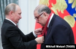 Russian President Vladimir Putin (left) awards Alisher Usmanov Russia's Order of Merit for the Fatherland (3rd class) at a ceremony at the Kremlin in Moscow in November 2018.