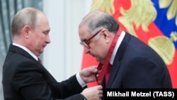 Russian President Vladimir Putin (left) presents Alisher Usmanov with an award at a ceremony at the Kremlin in Moscow in 2018. 