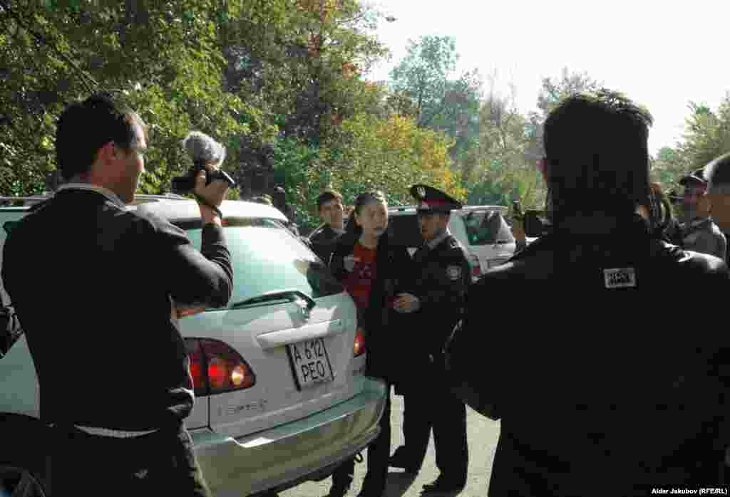 Полицейские уводят зачинщицу срыва пресс-конференции оппозиционеров Гульбахрам Жунис - Полицейские уводят Гульбахрам Жунис, зачинщицу срыва пресс-конференции оппозиционеров. Алматы, 27 октября 2010 года.