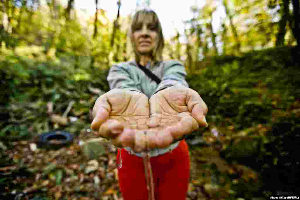 Kravchenko shows a sample of clean water from a stream uphill from the garbage dump.