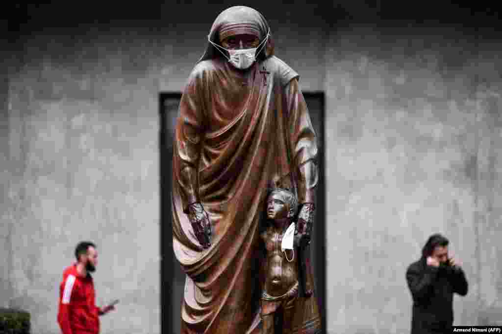 A statue of Saint Teresa in Kosovo&#39;s capital, Pristina, is covered with a surgical mask on December 19. (AFP/Armend Nimani)