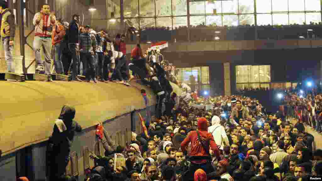 People gather around a train as they wait in Cairo for the arrival of those wounded during deadly rioting at a soccer stadium in Port Said. (REUTERS)