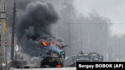 Російський бронетранспортер (БТР) горить під час бою з бійцями Збройних сил України на околиці Харкова, 27 лютого 2022 року