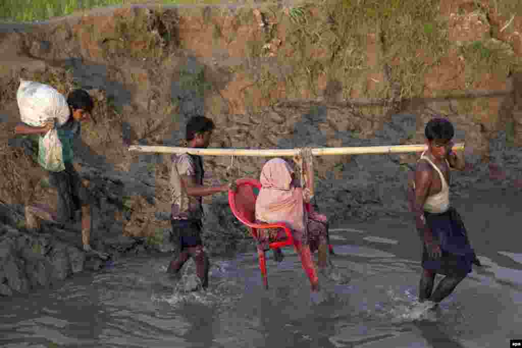 Rohingya Muslims assist an elderly woman as they enter Bangladesh near the Bangladesh-Burma border in Teknaf, Bangladesh. At least 87,000 members of the Rohingya Muslim minority have entered Bangladesh in the last week fleeing violence in northwestern Burma (also known as Myanmar). (epa/Stringer)