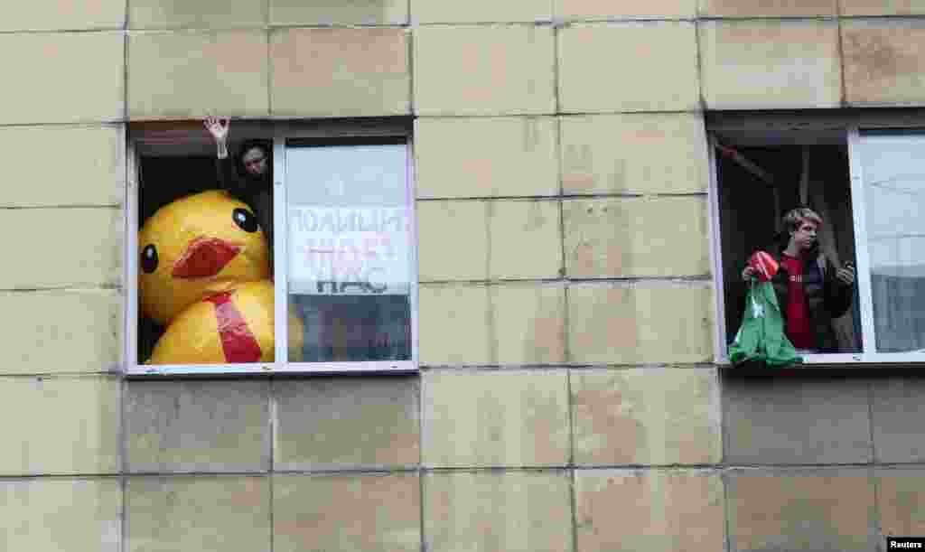 Supporters of Russian opposition leader Aleksei Navalny look out of windows during a rally for a boycott of the March 18 presidential election in St. Petersburg on January 28. (Reuters/Anton Vaganov)